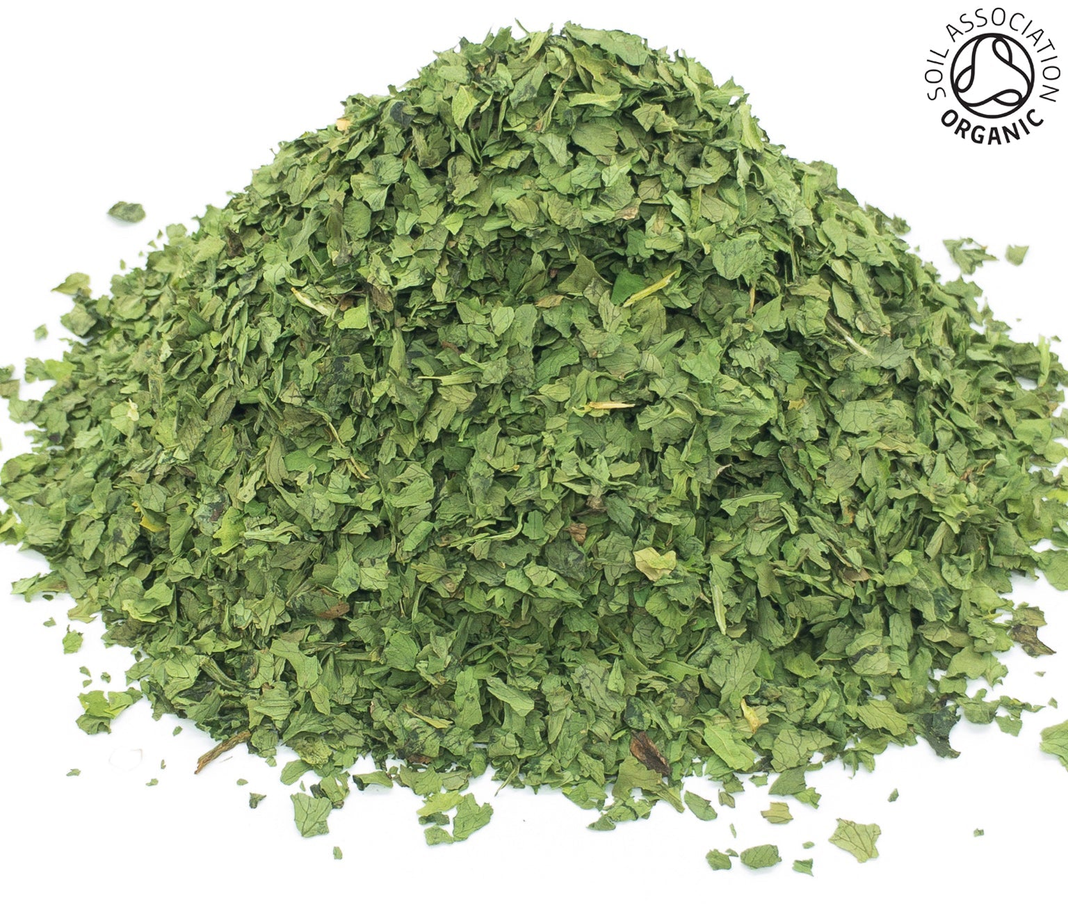 A small pile of dried, cut, organic coriander leaves, on a white background with the Soil Association Organic Logo in the top right corner
