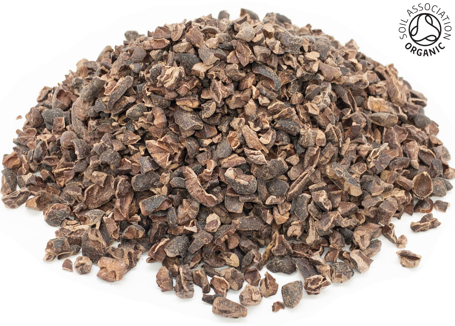 A small pile of dried, cut, organic cacao nib pieces on a white background with the Soil Association Organic Logo in the top right corner