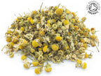 A small pile of dried, chamomile camomile flower buds on a white background with the Soil Association Organic Logo in the top right corner