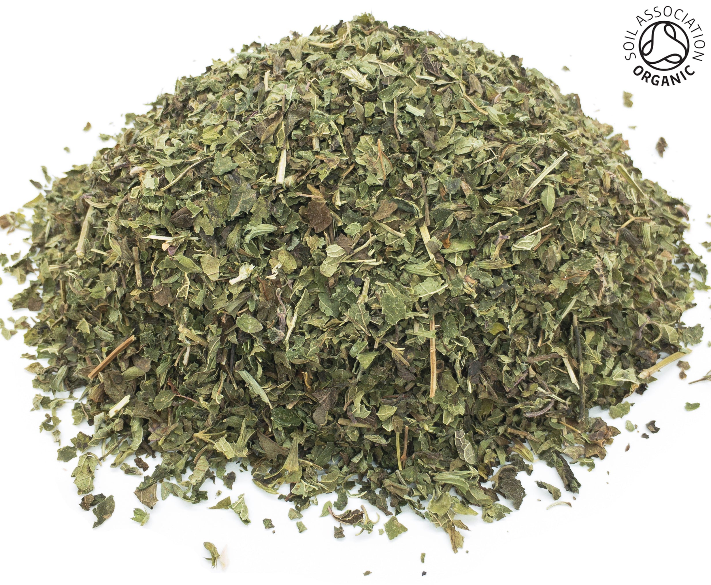 A small heap of cut, dried, organic lemon balm green herb leaf and stem on a white background with the Soil Association Organic Logo in the top right corner