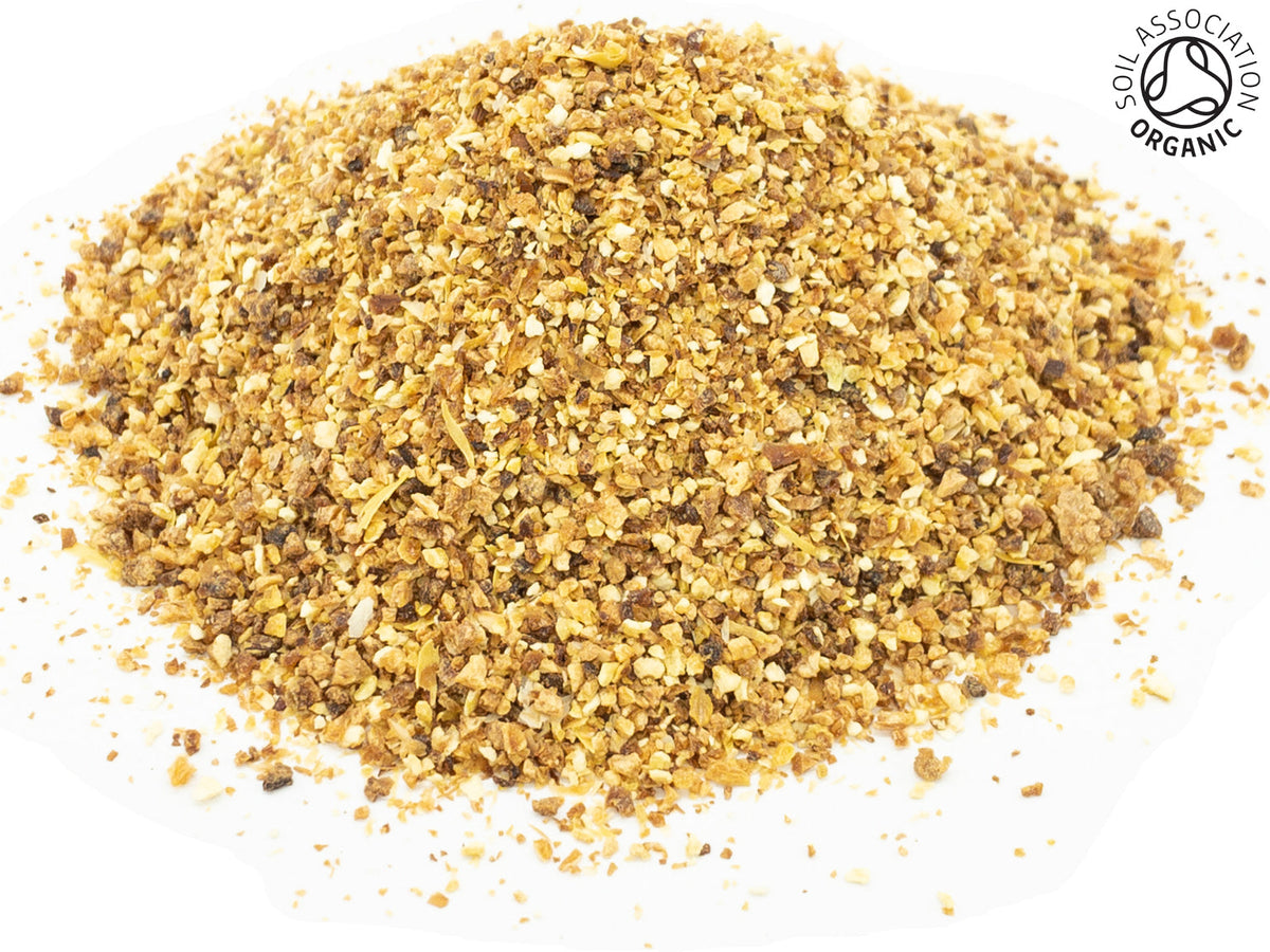 A small pile of dried, cut lemon fruit pieces on a white background with the Soil Association organic logo in the top right hand corner