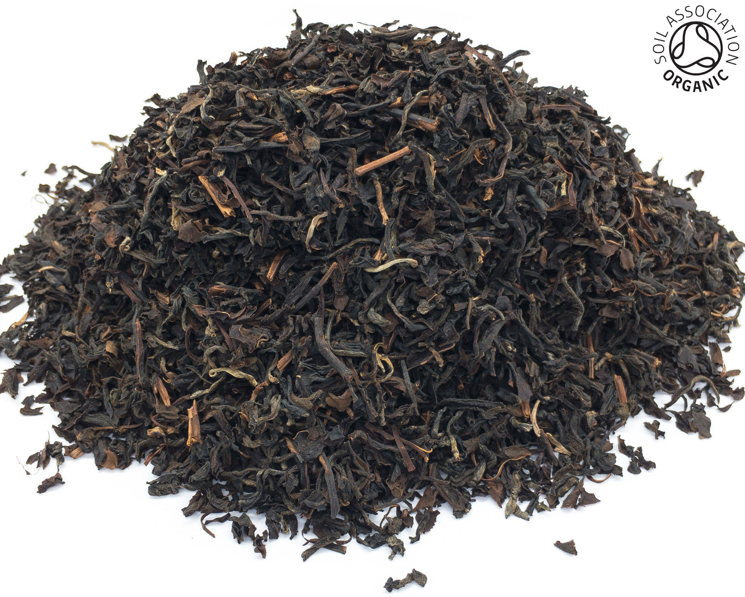 A small pile of dried, organin nam lanh black tea leaves on a white background