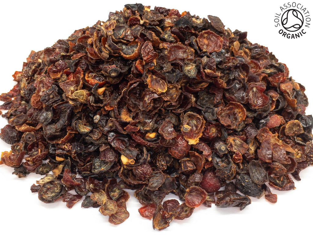 A small pile of dried, cut, organic rosehip fruit shells on a white background with the Soil Association Organic Logo in the top right corner
