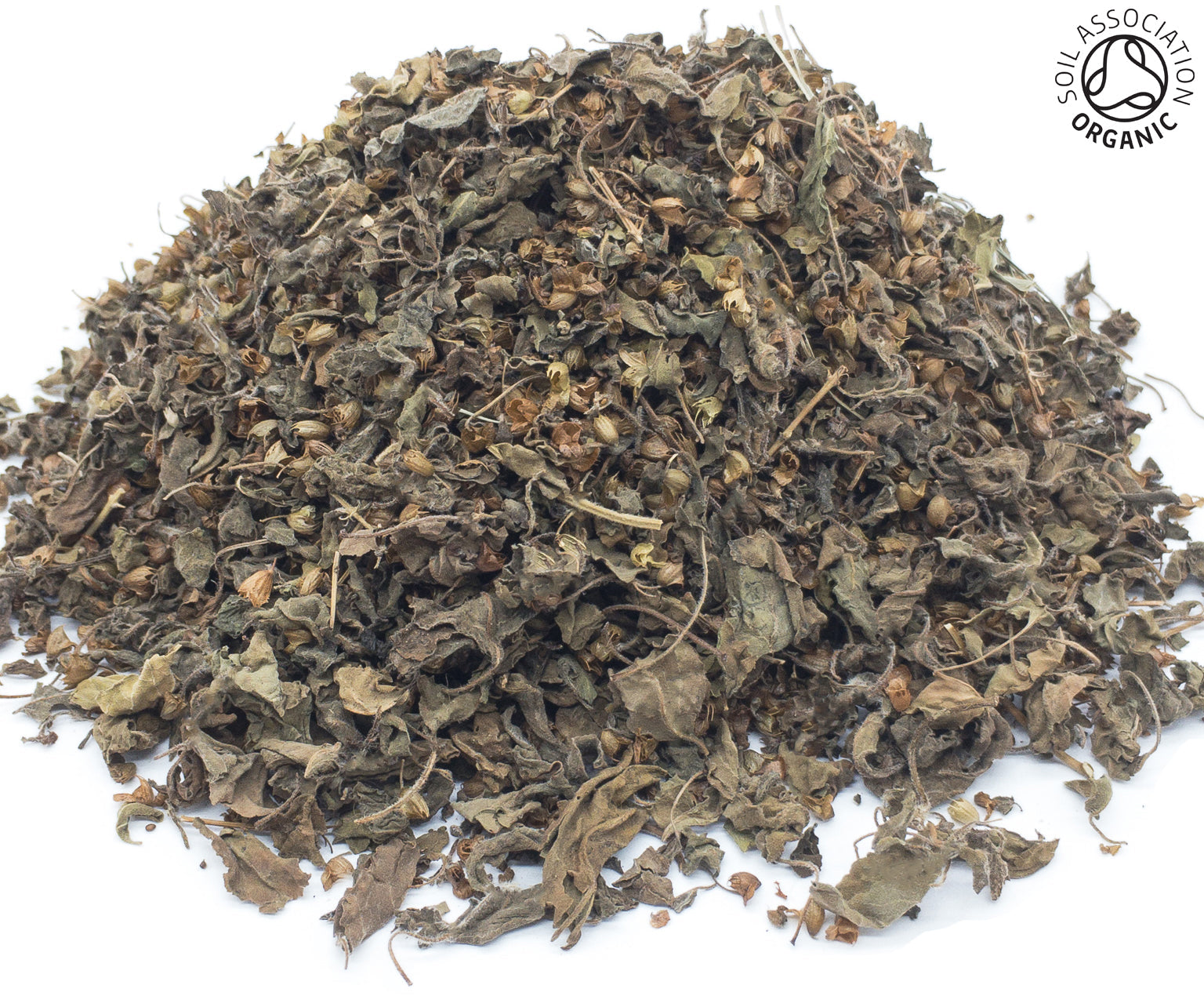 A small pile of dried, cut, organic tulsi/tulasi herb on a white background with the Soil Association Organic Logo in the top right corner