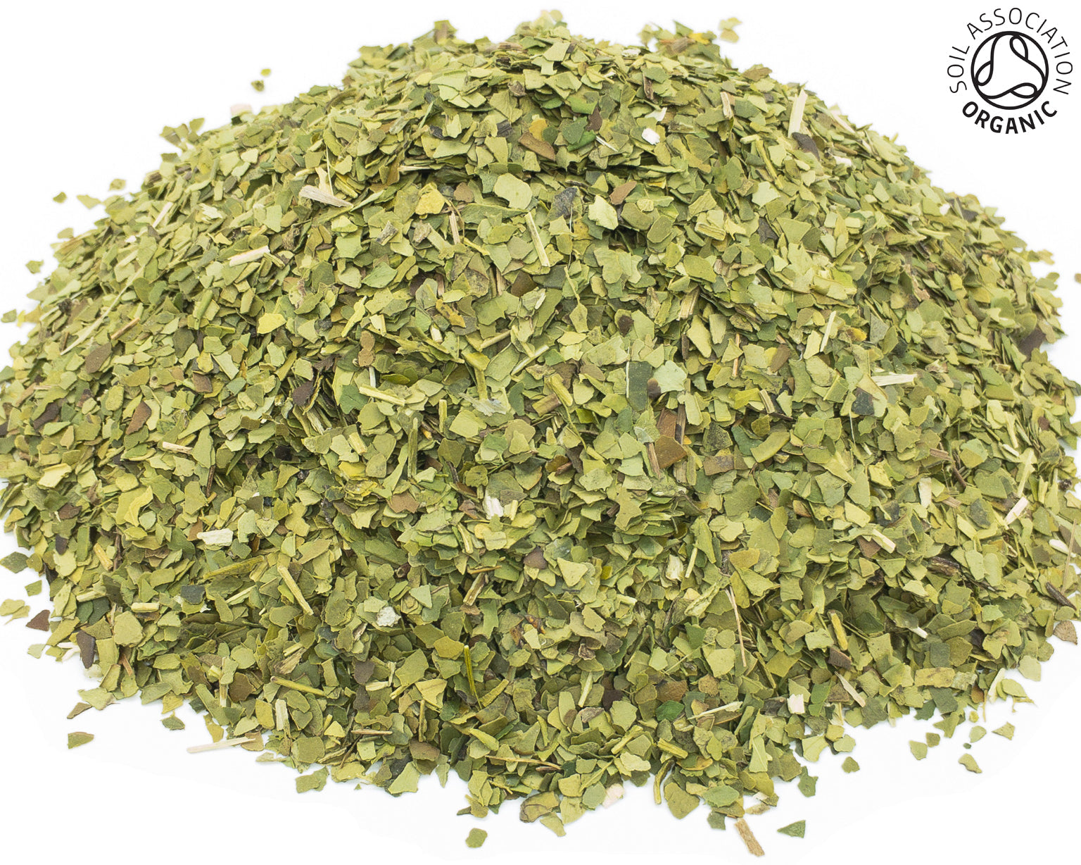 A small pile of dried, cut, green yerba mate leaves on a white background with the Soil Association organic logo in the top right hand corner.
